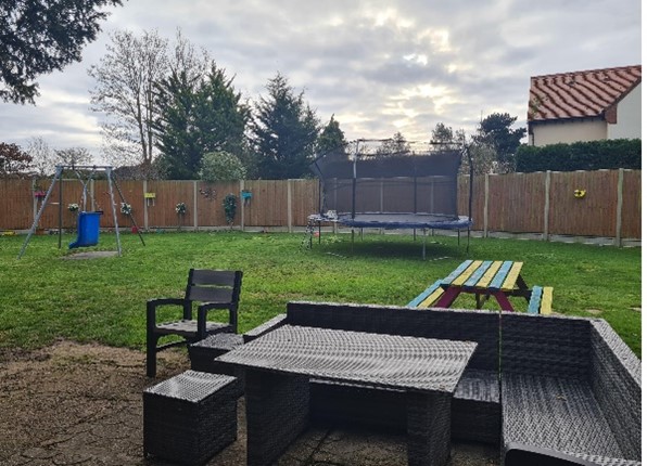 Garden with table, trampoline and swing