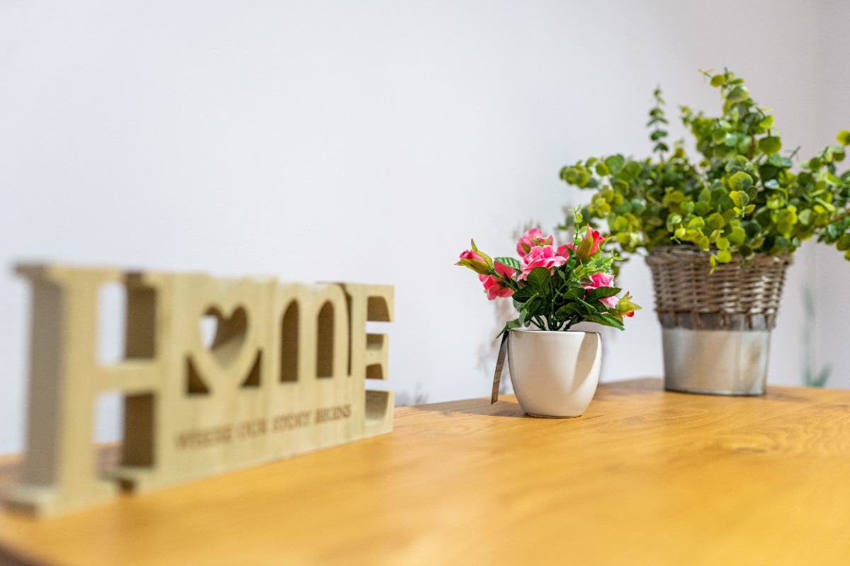 Home sign on a table with plants
