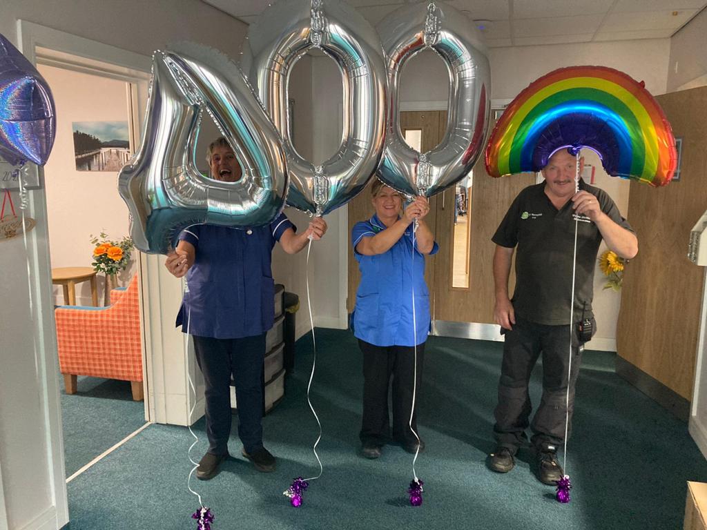 3 people holding balloons